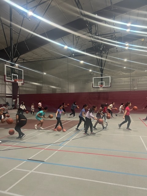 Large group practice session dribbling drills in big gymnasium